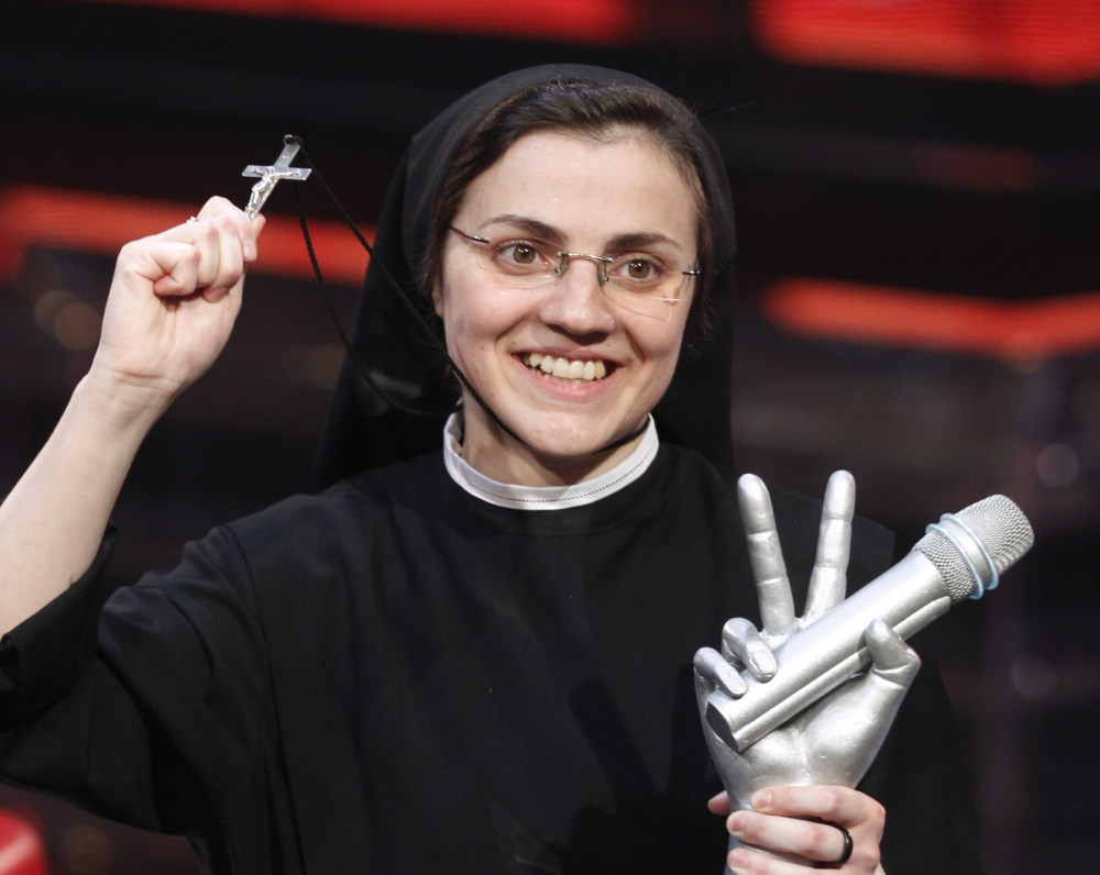 Sister Cristina Scuccia poses with the trophy and holding a cross after winning the final of the Italian version of the TV talent show “The Voice” in Milan, Italy, on Friday. The Associated Press 