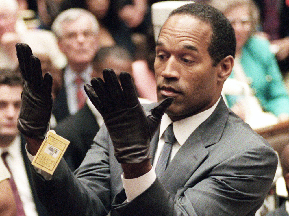 The Associated Press O.J. Simpson holds up his hands before the jury after putting on a new pair of gloves similar to the infamous bloody glove during his double-murder trial in Los Angeles on June 21, 1995. Associated Press writer Linda Deutsch is seen in the background at right; writer Dominick Dunne is in the background at left rear.