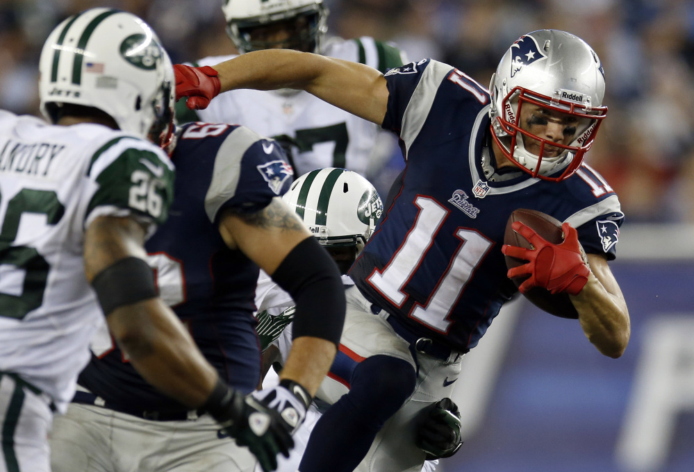 The Associated Press/Elise Amendola In this September 2013 file photo, New England Patriots wide receiver Julian Edelman (11) runs past New York Jets strong safety Dawan Landry (26) during ta game in Foxborough, Mass. Edelman surprisingly emerged as the Patriots top receiver last season. And he says he won’t change just because he signed a big contract in the offseason.