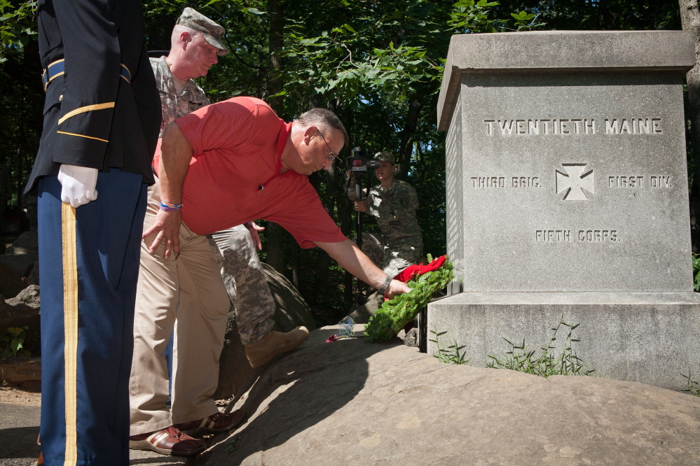 Gov. Paul LePage, accompanied by Brig. Gen. James Campbell, participates in a wreath-laying ceremony at the Twentieth Maine memorial at Gettysburg National Military Park in Pennsylvania last July. Some critics of Campbell’s leadership style say he rules like a drill sergeant and has a “my way or the highway” mentality reminiscent of LePage, the man who appointed him to lead the Maine National Guard in 2012. 
2013 Telegram file photo by John Boal