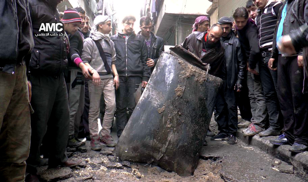 Syrians inspect an unexploded barrel bomb in January that reportedly was dropped from a government helicopter in Aleppo. Barrel bombs also have been used in Iraq and Sudan. The Associated Press