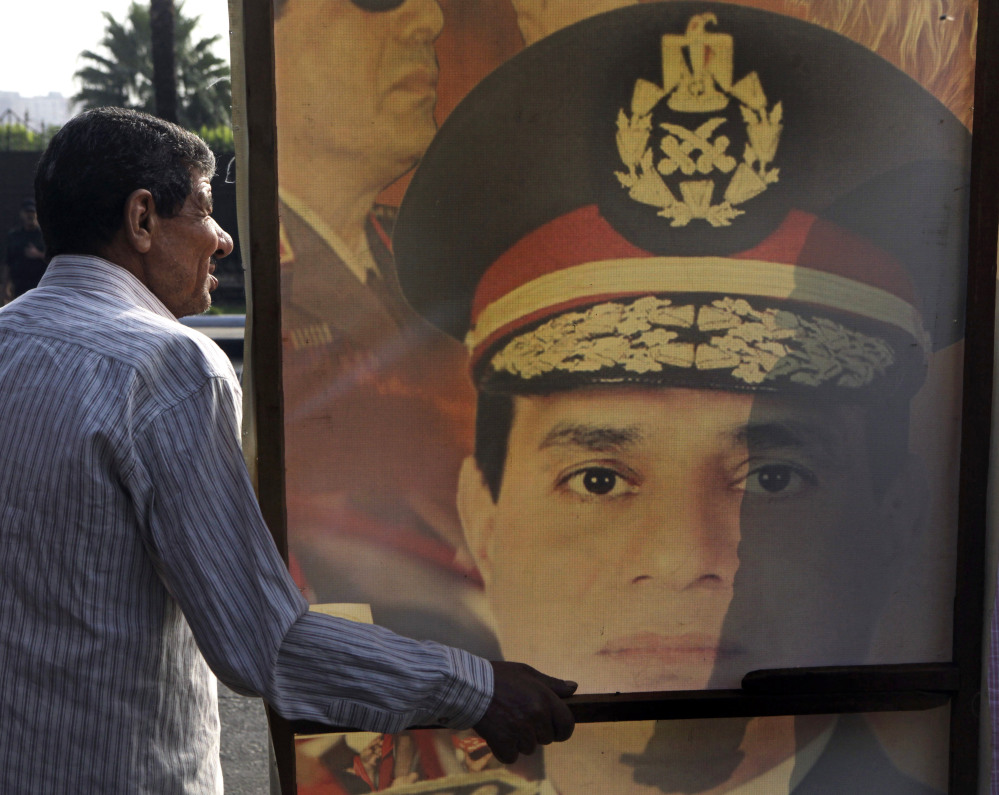 A supporter of new Egyptian President Abdel-Fattah el-Sissi holds a poster with a photo of him Sunday in Cairo, where thousands celebrated the former military chief’s inauguration. The Associated Press