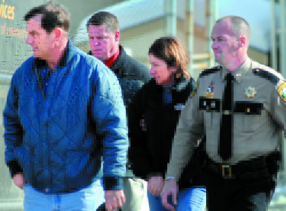 Former Chelsea Selectwoman Carole Swan, second from right, is led to the Kennebec County jail in handcuffs in 2011 after she was arrested at the sheriff’s office in Augusta. Swan was accompanied by, from left, her husband, Marshall Swan, after Detective David Bucknam and Sheriff Randall Liberty arrested her. Kennebec Journal File Photo/Andy Molloy