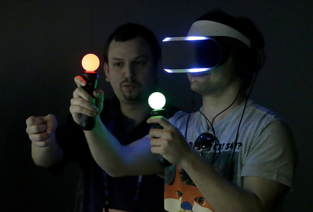 The Associated Press
In this March 19, 2014 file photo, Marcus Ingvarsson, right, tests out the PlayStation 4 virtual reality headset Project Morpheus in a demo area at the Game Developers Conference 2014 in San Francisco.