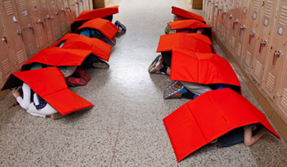 ProTecht photo Children wearing the BodyGuard blanket kneel in a school hallway during a tornado drill.