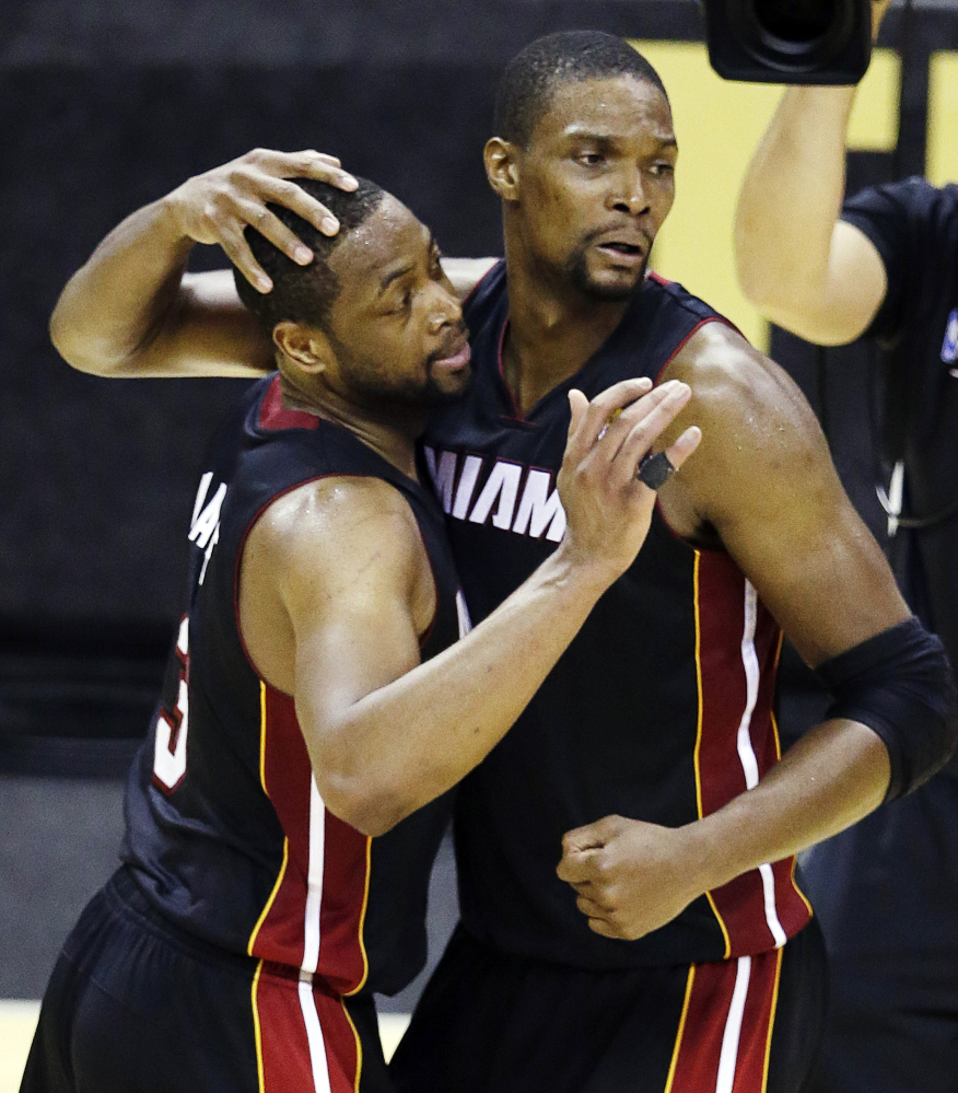 In this file photo from June 8, 2014, Miami Heat guard Dwyane Wade (3) and Chris Bosh celebrate after Game 2 of the NBA basketball finals against the San Antonio Spurs in San Antonio. Miami won 98-96. Wade became the latest recipient of a flopping fine from the NBA on Monday, ordered to pay $5,000. The Associated Press/Tony Gutierrez
