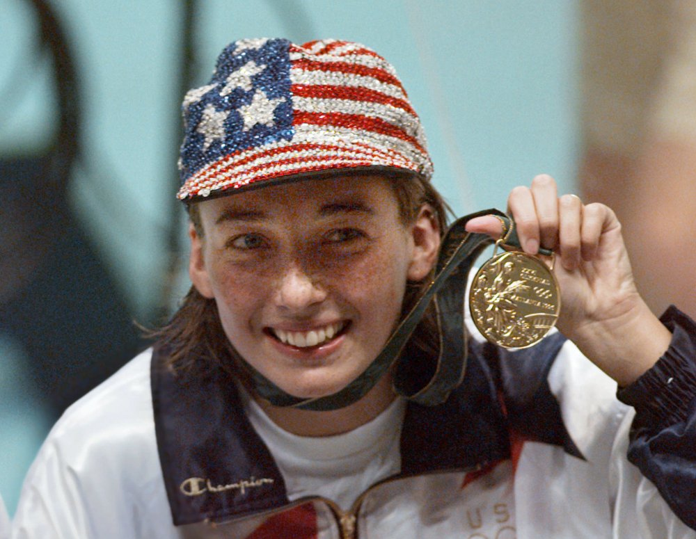In this July 26, 1996 file photo, Olympic gold medalist Amy Van Dyken holds her medal after winning the women's 50 meter freestyle at the 1996 Summer Olympic Games in Atlanta. Van Dyken has a severed spine after an accident on her all-terrain vehicle in Arizona. A hospital spokeswoman didn't provide details Monday on the injuries. The swimmer was hurt Friday night, June 6, 2014,  and told emergency workers at the scene she could not move her toes or feel anything touching her legs. The Associated Press/Lynne Sladky