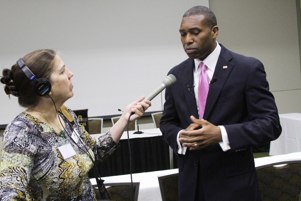 Associate U.S. Attorney General Tony West, right, speaks to reporters, including Lori Townsend with the Alaska Public Radio Network, left, about tribal voting rights on Monday, June 9, 2014, in Anchorage, Alaska. West updated delegates to the National Congress of American Indians on a plan announced earlier Monday by Attorney General Eric Holder, who will have his office consult with tribes across the country to develop ways to increase voting access for American Indians and Alaska Natives. The Associated Press/Mark Thiessen 