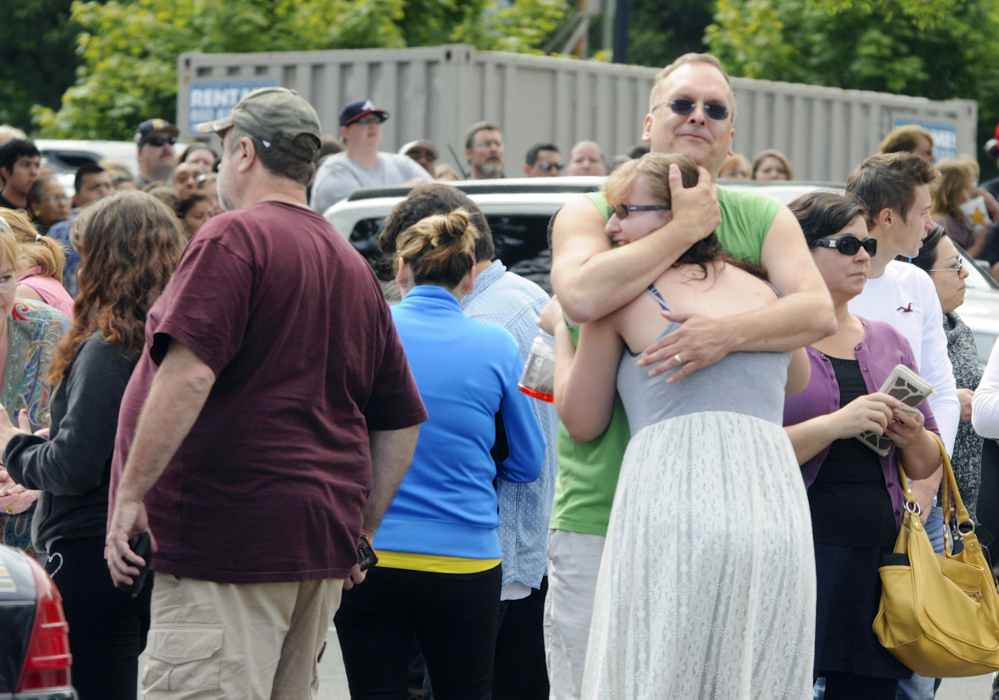 A family embraces as students arrived at the Fred Meyer grocery store parking lot in Wood Village, Ore., after a shooting at Reynolds High School on Tuesday.