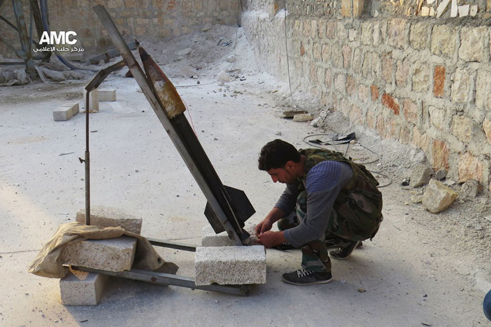 This photo provided by the anti-government activist group Aleppo Media Center (AMC), which has been authenticated based on its contents and other AP reporting, shows a Free Syrian Army fighter as he prepares a locally made missile to be fired against Syrian government forces, in Aleppo, Syria, Tuesday June 10, 2014. This photo provided by the anti-government activist group Aleppo Media Center (AMC), which has been authenticated based on its contents and other AP reporting, shows a locally made shell being fired by the Free Syrian Army towards Syrian government forces, in Aleppo, Syria, Tuesday June 10, 2014. Fighting in eastern Syria between the Islamic rebel brigades and an al-Qaida splinter group has killed more than 630 people and uprooted at least 130,000 since the end of April, an activist group said Tuesday. The Associated Press/Aleppo Media Center