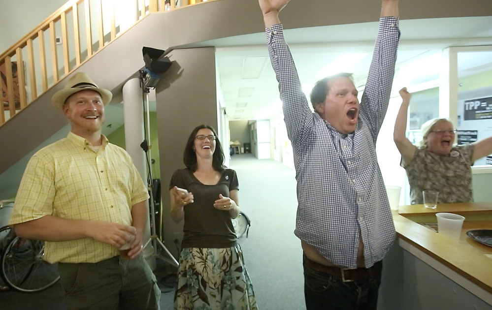 Volunteer Chris Moore, right, celebrates the win by the Yes on 1 campaign in Portland on Tuesday night, joined by his wife, Bree LaCasse, center, and City Councilor David Marshall. “We hope city officials heard us loud and clear,” LaCasse said. Gregory Rec/Staff Photographer