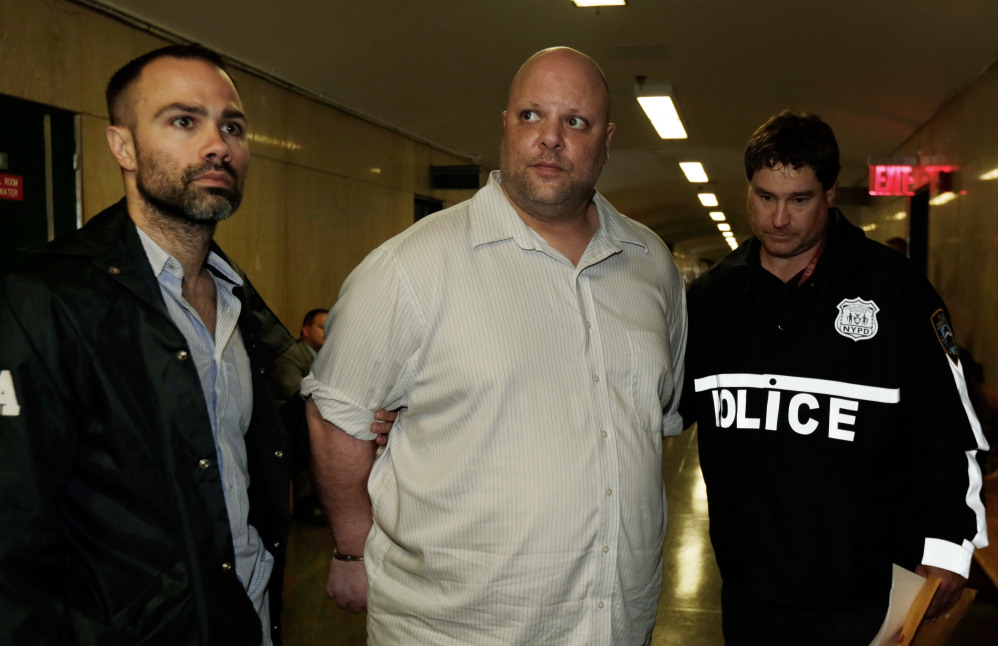 Carmine Vitolo, center, manager of a strip club in Queens, is escorted to court by police in New York, Wednesday.