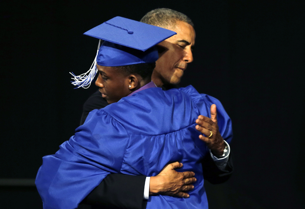President Barack Obama embraces student Martin Maina during the graduation ceremony for Worcester Technical High School in Worcester, Mass., Wednesday.