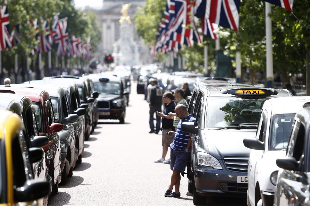 London cabbies stand alongside parked taxis on The Mall, leading away from Buckingham Palace, during a protest against Uber Technologies’ car sharing service on Wednesday.