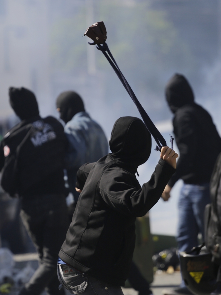 A protester winds up to sling a stone at police after clashes erupted in Sao Paulo on Thursday.