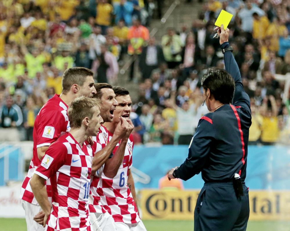 Croatia players argue after being given a penalty by referee Yuichi Nishimura from Japan during the group A World Cup soccer match between Brazil and Croatia, the opening game of the tournament, in the Itaquerao Stadium in Sao Paulo, Brazil, Thursday, June 12, 2014.
