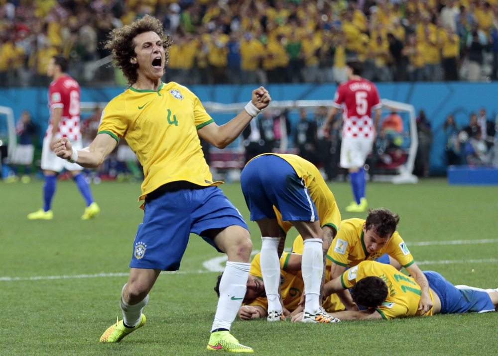 Brazil’s David Luiz (4) celebrates teammate Oscar’s (11) goal during the group A World Cup soccer match between Brazil and Croatia, the opening game of the tournament, in the Itaquerao Stadium in Sao Paulo, Brazil, Thursday, June 12, 2014.