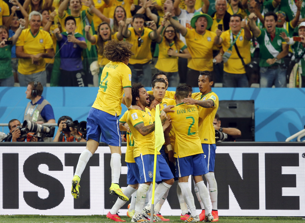 Fans cheer as Brazil players celebrate after scoring on a penalty kick during their group A World Cup soccer match against Croatia in the opening game of the tournament at Itaquerao Stadium in Sao Paulo, Brazil, Thursday, June 12, 2014. Brazil won the match 3-1.