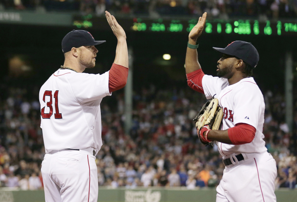 Boston Red Sox starting pitcher Jon Lester, left, congratulates center fielder Jackie Bradley Jr. after catching a fly out by Cleveland Indians Michael Bourn, and throwing out base runner Mike Aviles off first, to end the top of the seventh inning on Thursday.