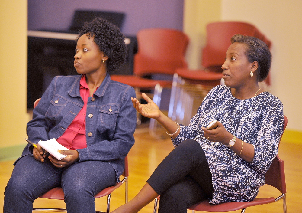 Ridelphine Katabesha, left, who immigrated from the Democratic Republic of the Congo, listens to Mia Ntahobari discuss the cutoff of state aid for some immigrants at a meeting of the Maine Immigrant Women’s Network, which drew 20 women from a variety of Portland groups.