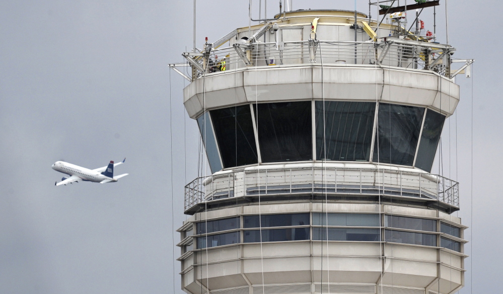 A passenger jet flies past the FAA control tower at Washington’s Ronald Reagan National Airport in this undated photo. Studies show most night shift workers, not just controllers, face difficulties staying awake no matter how much sleep they’ve had. That’s especially true if they aren’t active or don’t have work that keeps them mentally engaged.