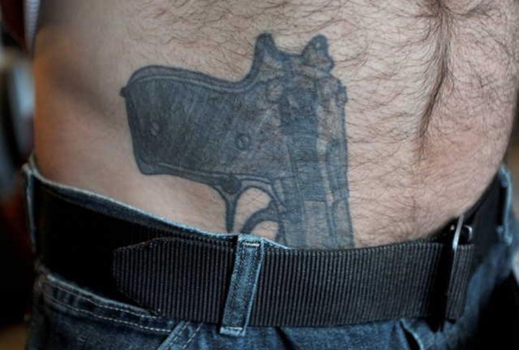 A close-up of Michael Smith’s gun tattoo.