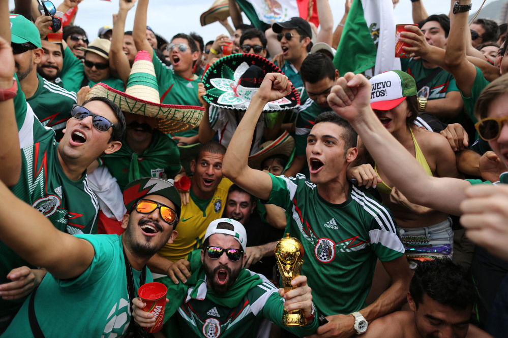 Mexico soccer fans celebrate their team’s 1-0 victory over Cameroon at a World Cup match, inside the FIFA Fan fest area on Copacabana beach in Rio de Janeiro, Brazil, Friday, June 13, 2014.