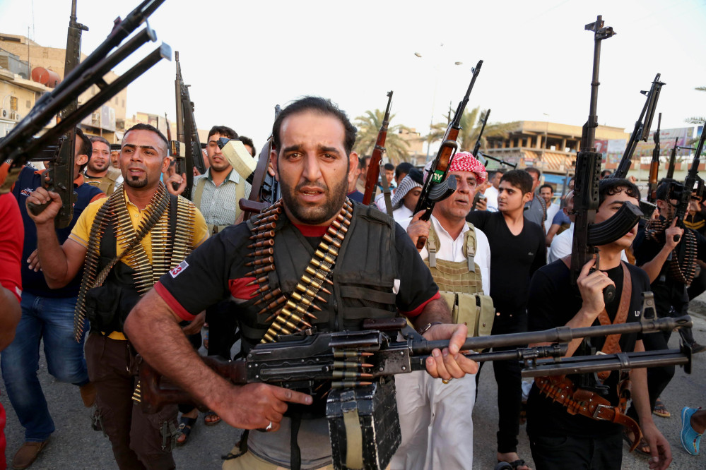 Iraqi Shiite tribal fighters deploy with their weapons while chanting slogans against the al-Qaida-inspired Islamic State of Iraq and the Levant, in order to help the military in defending the capital in Baghdad’s Sadr City, Iraq, on Friday.