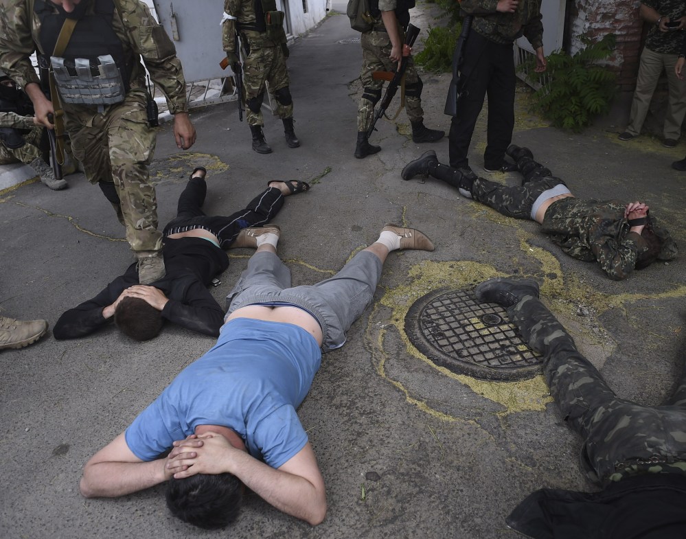 Ukrainian troops from battalion Azov ground men detained at the site of a battle with pro-Russian separatists in Mariupol, eastern Ukraine, on Friday.