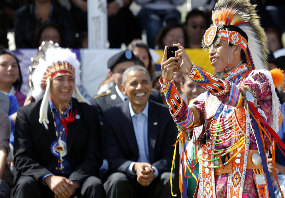 A dancer takes a selfie with President Obama, and chairman if the Standing Rock Sioux Tribe David Archambault, left, at Standing Rock Indian Reservation in Cannon Ball, N.D., on Friday
