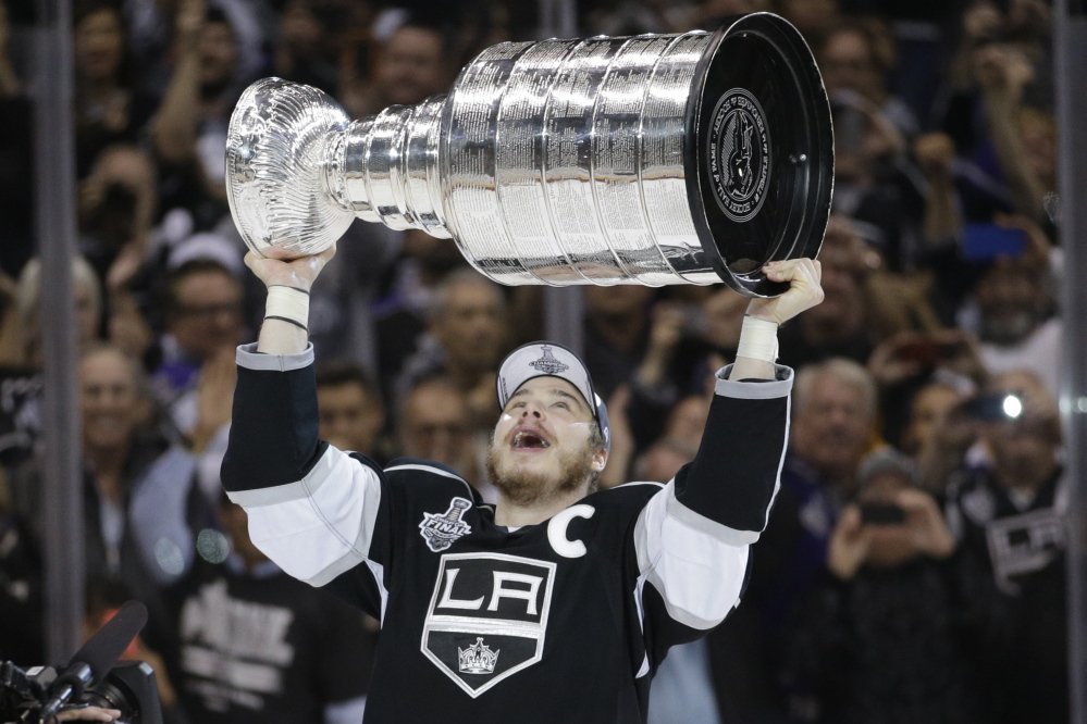 Los Angeles Kings right wing Dustin Brown raises the Stanley Cup after the Kings beat the New York Rangers in overtime in Game 5 of the Stanley Cup Final series Friday in Los Angeles.
