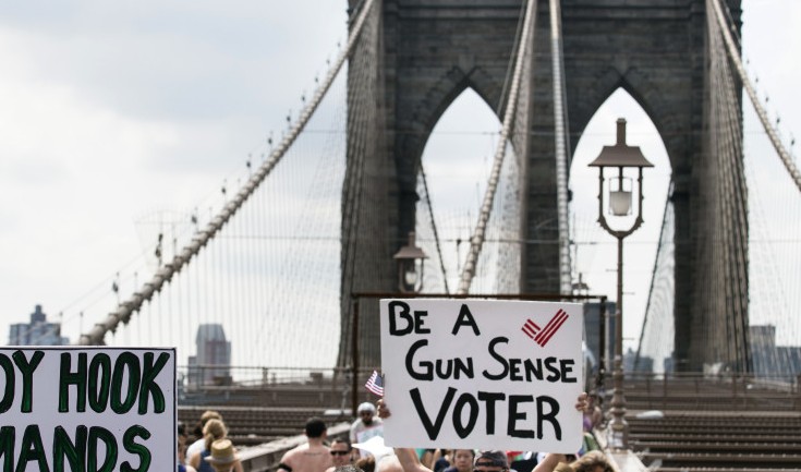 Demonstrators raise posters as they march across the Brooklyn Bridge to call for tougher gun control laws on Saturday in New York. The protest was underwritten by former New York Mayor Michael Bloomberg, one of the most visible gun control advocates in the U.S., and included relatives of some of those slain in the 2012 shooting rampage at Sandy Hook Elementary School in Newtown, Conn.
