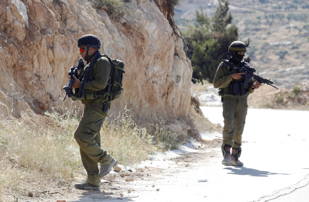 Israeli soldiers patrol during a military operation to search for three missing Israeli teenagers near the West Bank city of Hebron on Saturday. Israeli security forces searched the West Bank for a second day Saturday, looking for three missing teenagers, including an American, who they fear have been abducted by Palestinian militants.