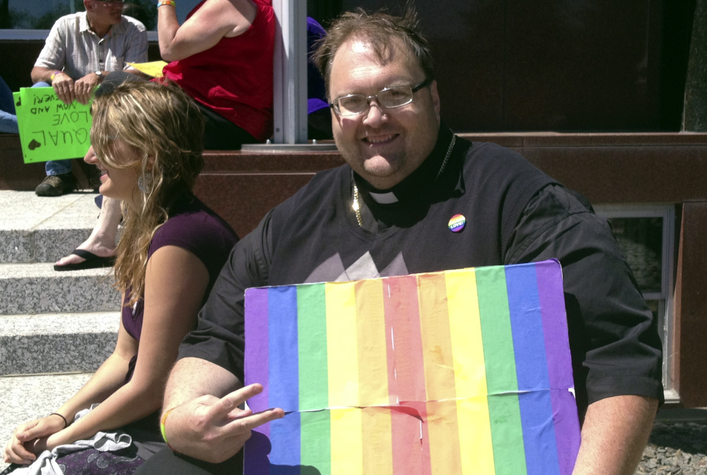 The Rev. Scott Crandall of Peace United Church of Christ joins 1demonstrators in front of the Portage County Courthouse on Friday in Stevens Point, Wis. About 50 people gathered to protest the county’s refusal to issue same-sex marriage licenses.