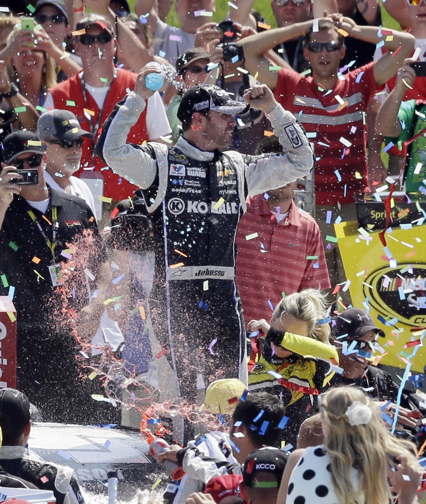 Jimmie Johnson celebrates in Victory Lane after the NASCAR Quicken Loans 400 auto race at Michigan International Speedway in Brooklyn, Mich., Sunday.