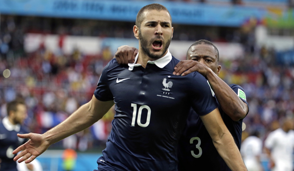 France’s Karim Benzema celebrates with teammate Patrice Evra after scoring the first of his two goals on a penalty kick during the Group E World Cup match between France and Honduras on Sunday at the Estadio Beira-Rio in Porto Alegre, Brazil. France never allowed a shot at its own net and won 3-0.