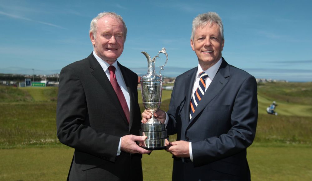 Northern Ireland Deputy First Minister Martin McGuinness, left, and First Minister Peter Robinson hold the Claret Jug trophy for the media to announce that golf’s oldest championship would return to Royal Portrush in Northern Ireland, Monday.