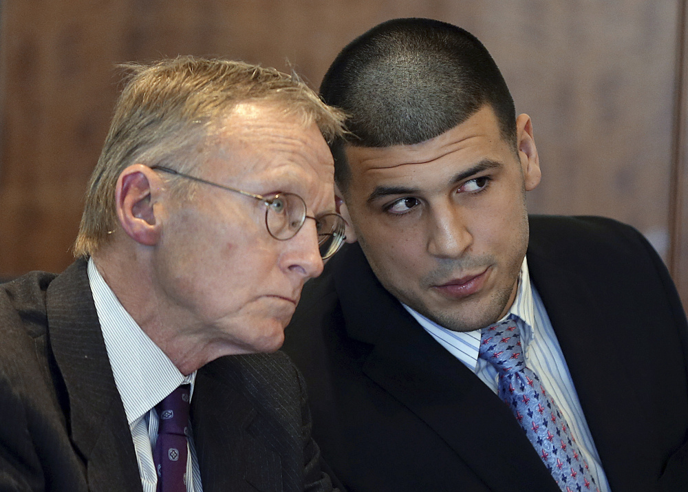 In this Friday, Feb. 7, 2014, file photo, former New England Patriots football player Aaron Hernandez, right, speaks to his attorney Charles Rankin during a hearing at Bristol Superior Court, in Fall River, Mass.
