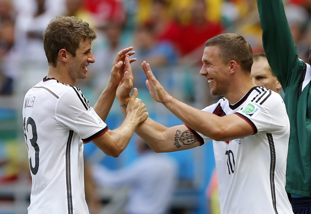 Germany’s Thomas Mueller, left, is greeted by Lukas Podolski after being substituted after scoring a hat-trick during the Group G World Cup soccer match between Germany and Portugal in Salvador, Brazil, on Monday.