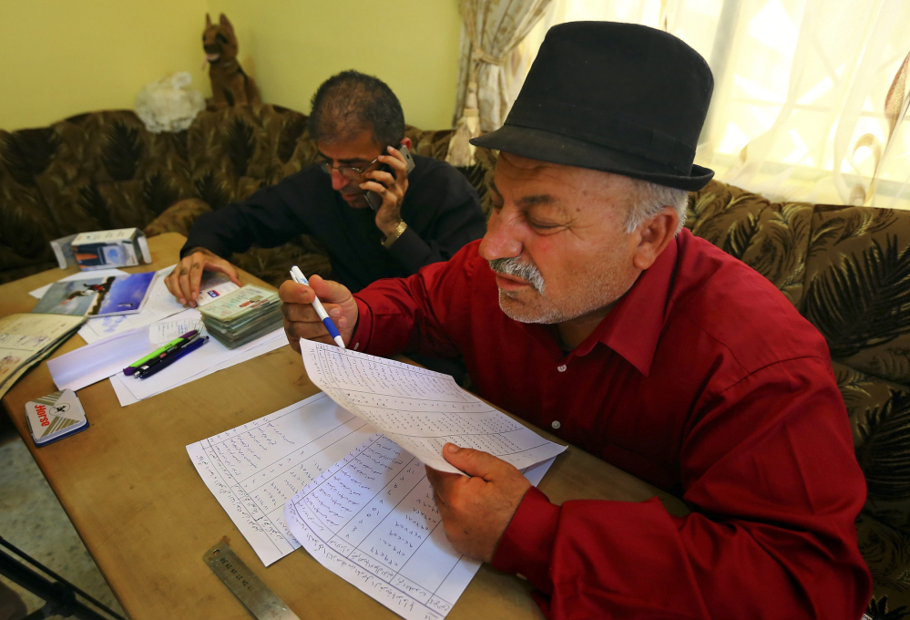 The mayor of Alqosh, Sabri Boutani, and Friar Gabriel Tooma check documents of internally displaced Iraqis to give them permission to stay in Alqosh, a village of some 6,000 inhabitants about 31 miles north of Mosul, northern Iraq.