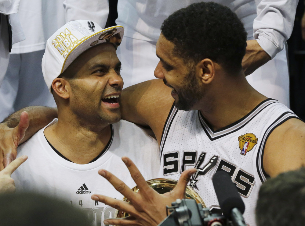 San Antonio Spurs guard Tony Parker, left, and forward Tim Duncan celebrate after Game 5 of the NBA basketball finals on Sunday, June 15, 2014, in San Antonio. The Spurs won the NBA championship 104-87.
