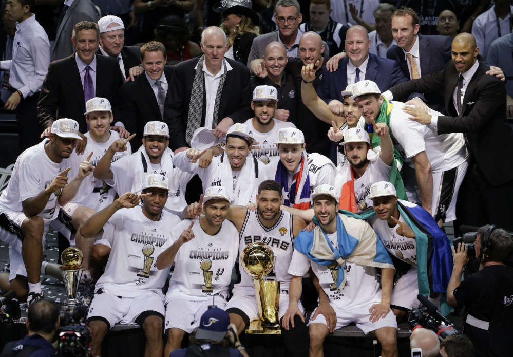 The San Antonio Spurs pose for a photo after Game 5 of the NBA basketball finals against the Miami Heat on Sunday, June 15, 2014, in San Antonio. The Spurs won the NBA championship 104-87.