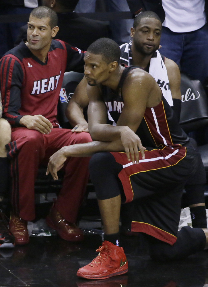 From left, Miami Heat forward Shane Battier,  center Chris Bosh and guard Dwyane Wade watch the final moments of Game 5 in the NBA basketball finals on Sunday, June 15, 2014, in San Antonio. San Antonio won the NBA championship 104-87.