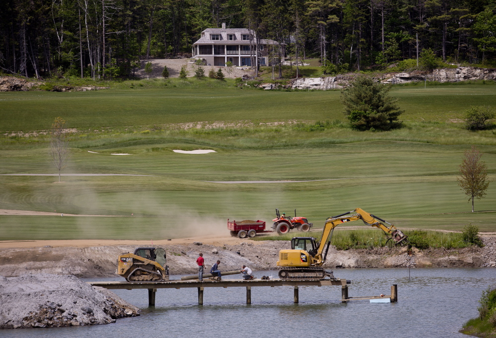 Workers build a bridge over a pond at the Boothbay Harbor Country Club on Wednesday. A “floating tee” where golfers can tee off on a tiny island will be one of many new features in the redesigned golf course.