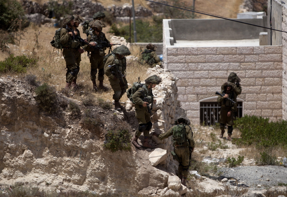 Israeli soldiers conduct a military operation to search for three missing teenagers outside the West Bank city of Hebron on Monday.