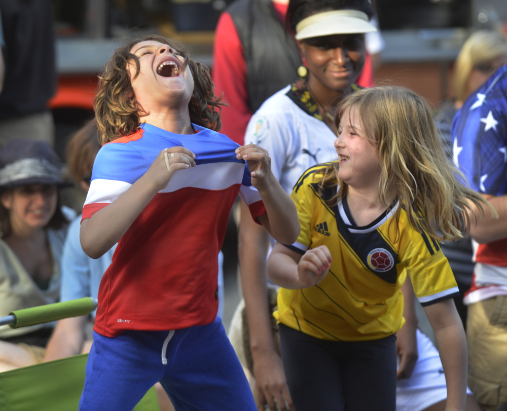 Portland community groups organized a World Cup viewing party Monday in Portland’s Congress Square Plaza. Diego Schair-Cardona, left, and his friend Sloan Gardner, both from Portland, react to the game’s first goal by the United States.