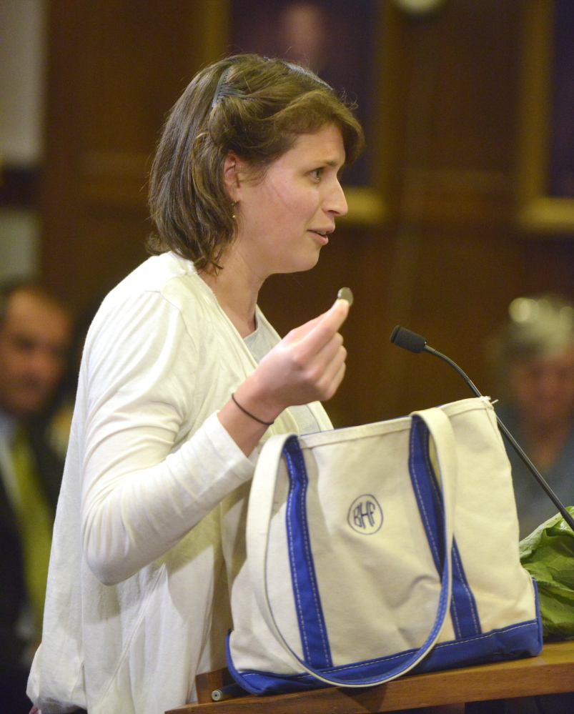 Bonny Frye Hemphill pulls a nickel from her canvas shopping bag Monday night during a discussion with the city council about a fee for disposable shopping bags in Portland.