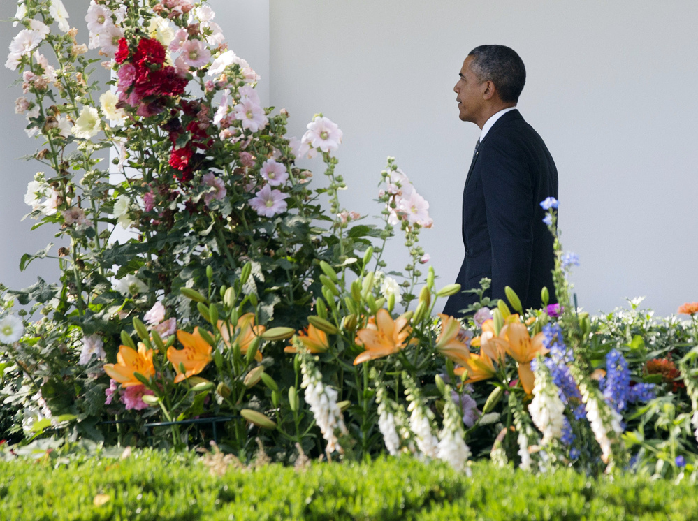 President Obama walks through the Rose Garden on his way into the White House Monday after returning from a trip to California. The White House announced he plans to sign an order banning federal contractors from employment discrimination based on sexual orientation.