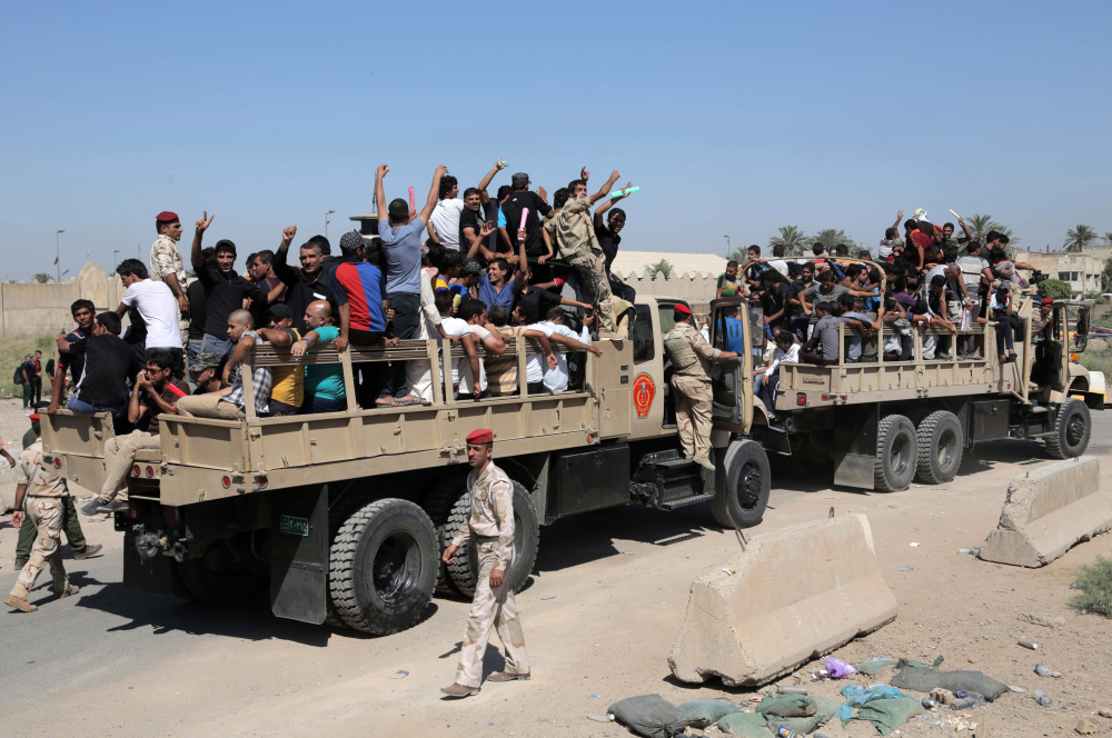 Iraqi men fill military trucks to join the Iraqi army at the main recruiting center in Baghdad on Tuesday, after authorities issued a call to arms to fight the  insurgents.