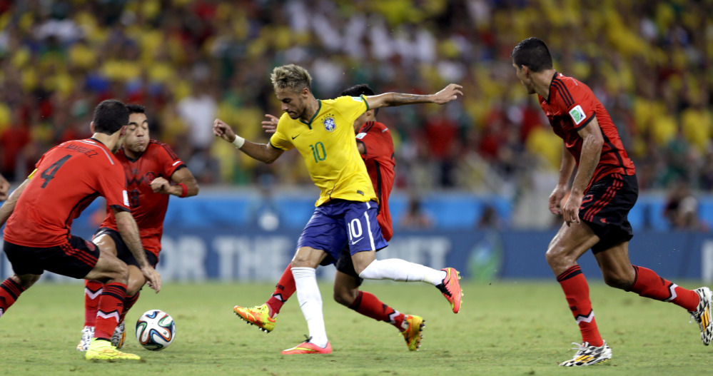 Brazil’s Neymar is closed down by the Mexico defense during the group A World Cup soccer match between Brazil and Mexico at the Arena Castelao in Fortaleza, Brazil, Tuesday, June 17, 2014.